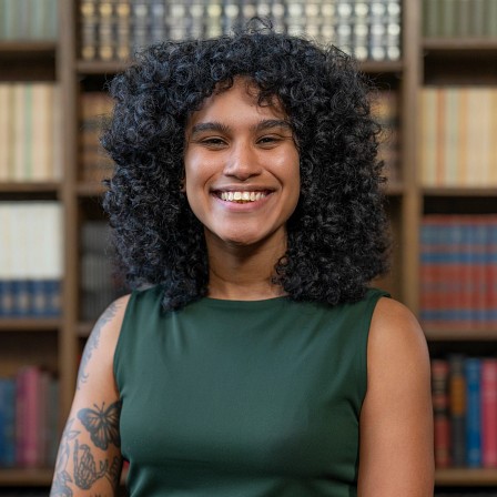 woman posing in front of book case