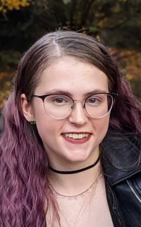 Amanda McKellips, a female-identifying individual, smiles at the camera