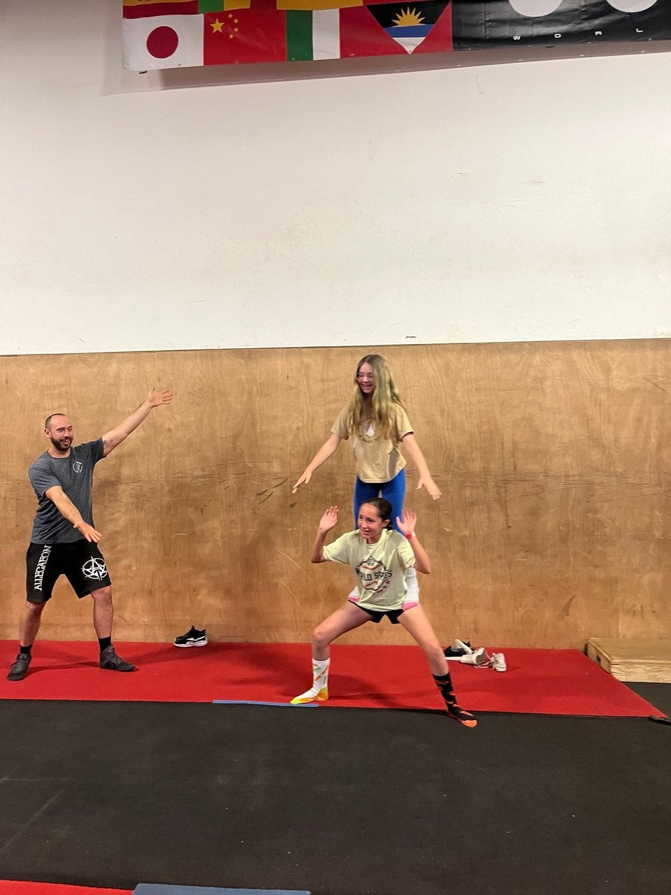 A man and woman engage in a dynamic trampoline stunt, highlighting their skill and synchronization in mid-air.