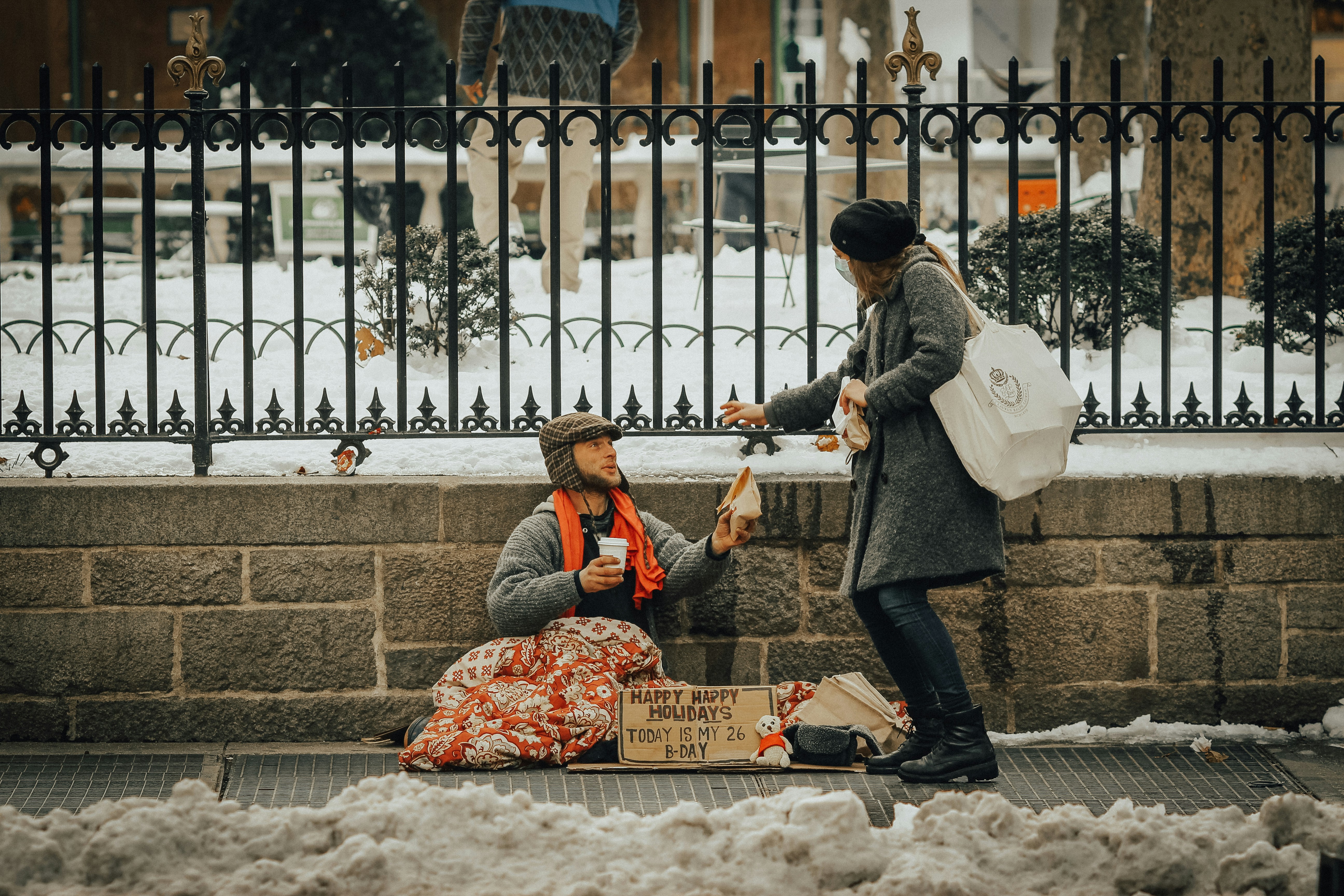 Person handing something to a homeless person