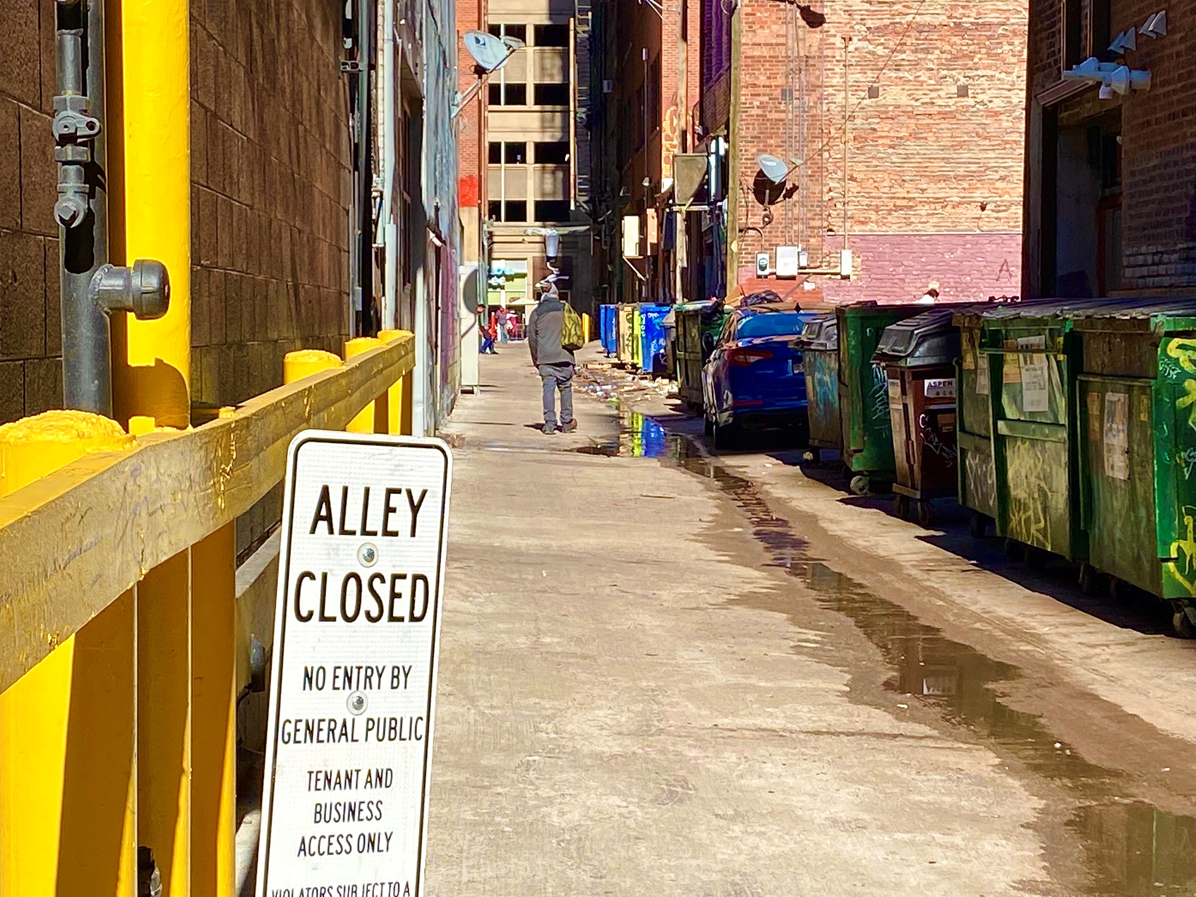 man with backpack in alleyway