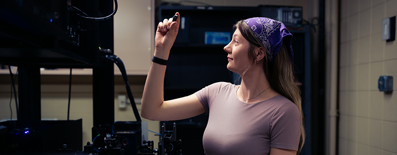 a student looking at a piece of glass in physics lab