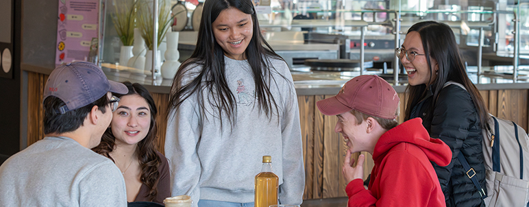 a group of students talking at dining commons