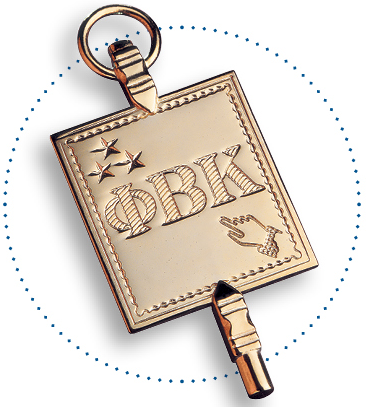 close-up of golden Phi Beta Kappa membership pin, with Greek acronym below 3 stars, and above outstretched hand