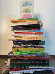 Book piled upon book representing the stress university students are under, advocating for more mental health access on campuses.