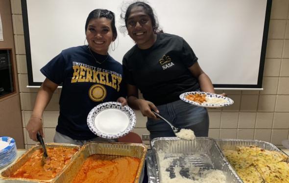 two girls smiling serving food