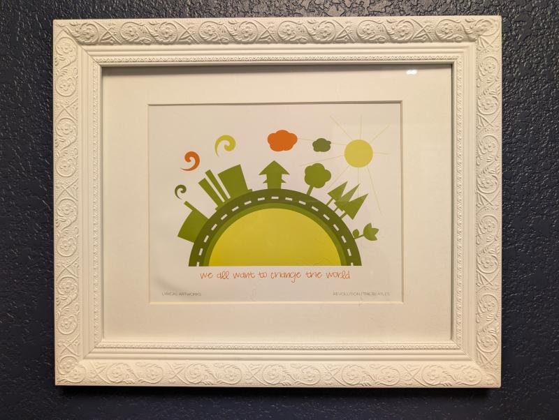  A framed graphic art piece of a road with the sun, buildings and trees featuring lyrics from Revolution by Lyrical Artworks