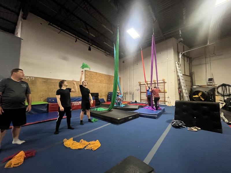 A lively gym scene featuring a group of individuals bouncing on trampolines, promoting fitness and teamwork.