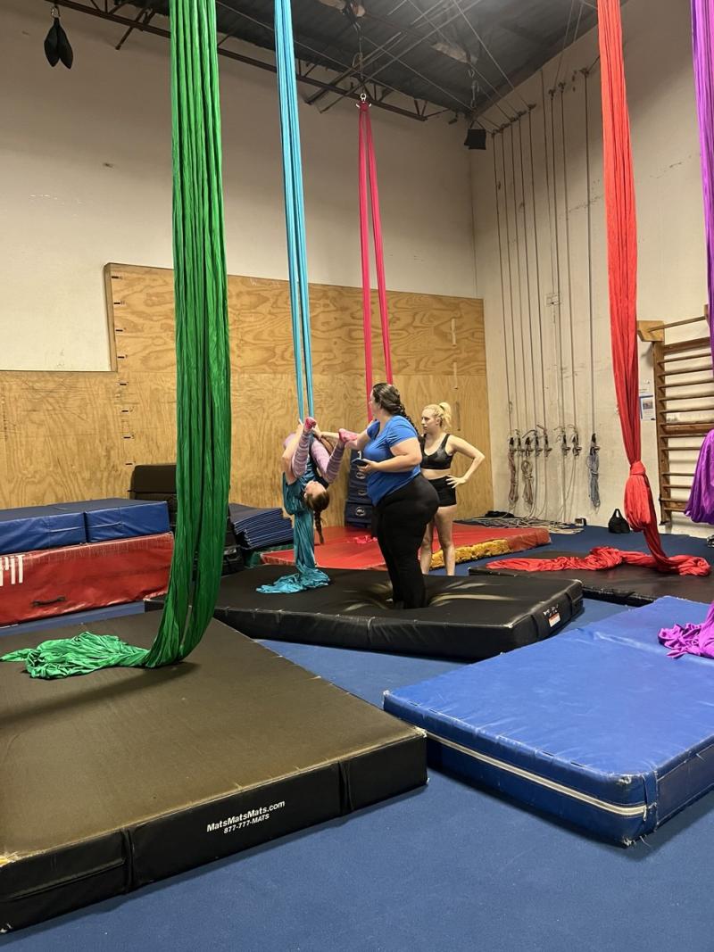 A team of individuals honing their trampoline skills, capturing the excitement and camaraderie of their practice session.