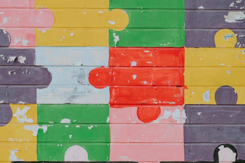 picture of a brick wall with puzzle pieces painted on