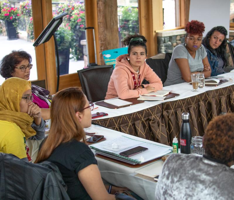 Group of individuals sitting in a round-table set-up discussing global initiatives