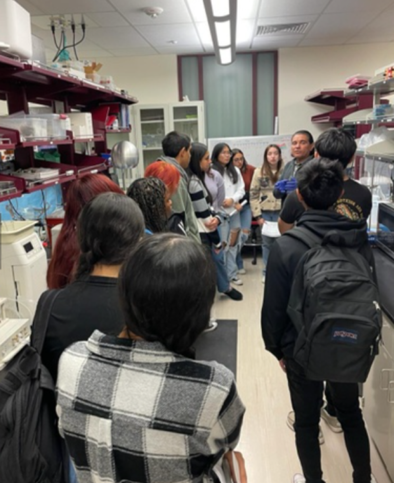 group of high school students with back towards camera in science room