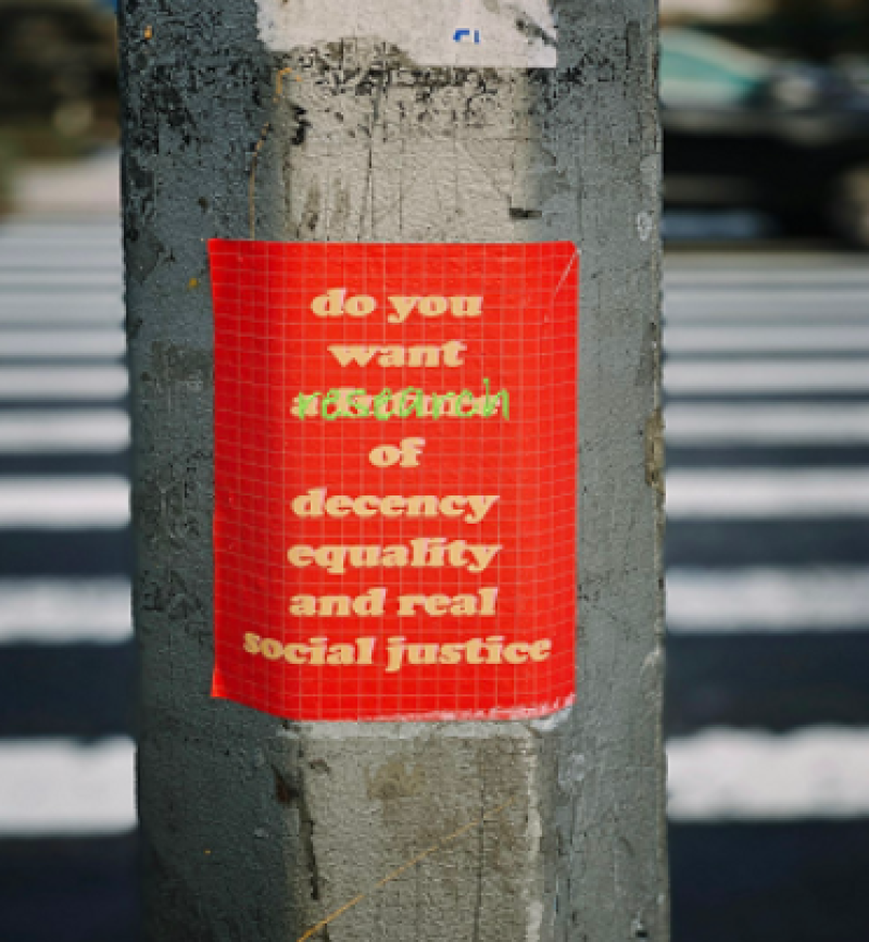 flyer on a wood pole that says do you want research of decency, equality, and real social justice