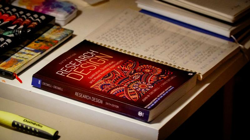 Reproach design book next to a note pad filled with notes.