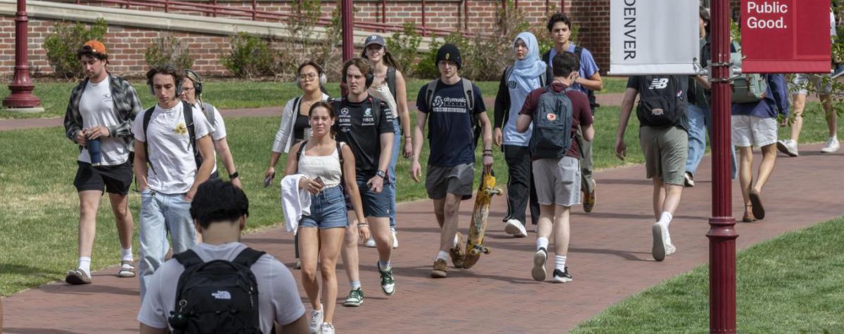 students walk outside across a campus walkway