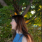Lydia M: Girl smiling side-profile with blue dress and trees in the background. 