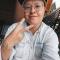 a person in glasses with fingers in form of a peace sign