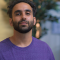 antony; a bearded man with greenery behind him