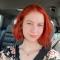Nicole: a red haired woman smiling into camera