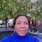 Nonye: a woman smiling into camera with trees in background