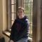 anna v: a brown haired woman in front of a sunny window