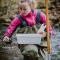 woman in river collecting water sample
