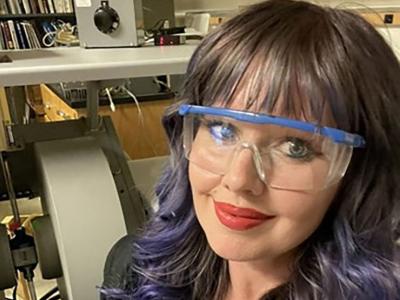Dark haired woman smiling into camera.