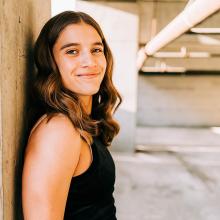 Woman in black shirt smiles at the camera