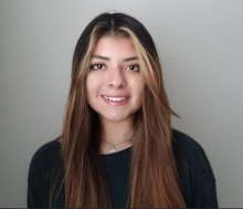 Alexa Fonseca Dark haired woman smiling into camera.