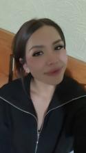Gisselle smiles with her dark hair pulled back. 