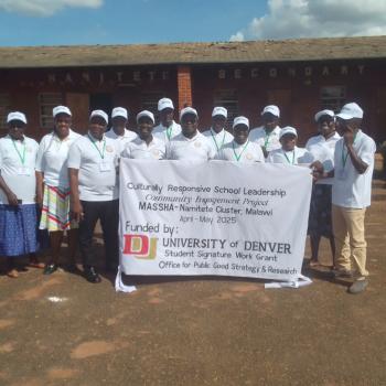 CE Fellows and Malawi Secondary Schools Head Teacher’s Association (MASSHA), in front of their school holding a banner noting their work.
