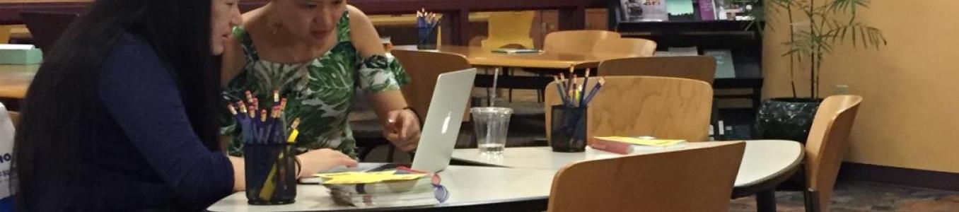 Two writers work on paper at writing center