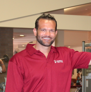 Person standing wearing red University of Denver polo shirt