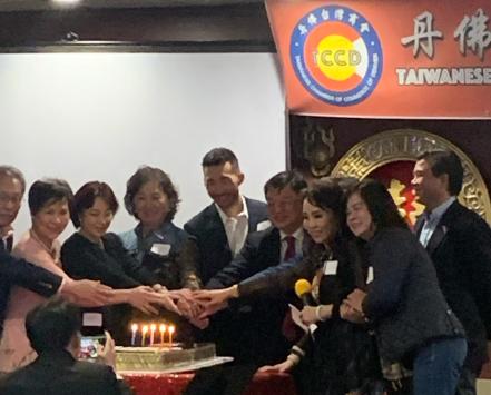 people posing with joined hands over a cake with candles