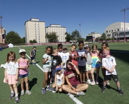 University of Denver student on soccer field with children