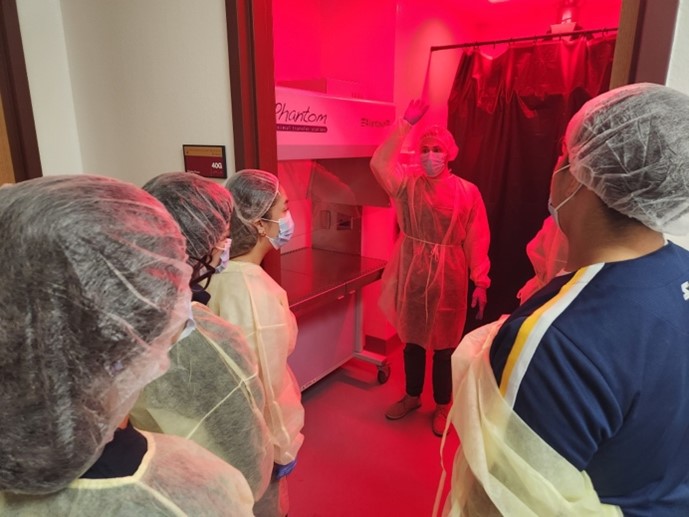 People in high altitude physiology lab wearing PPE in a room with a red light